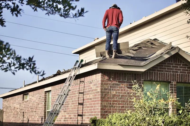 Professional roofer working on a residential roof in Olivarez